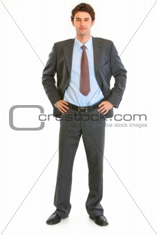 Full length portrait of modern young businessman with hands on hips
