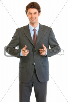 Smiling young businessman showing  thumbs up gesture
