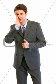 Smiling modern businessman reporting good news and  showing thumbs up gesture
