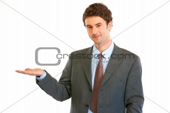 Smiling modern businessman presenting something on empty hand
