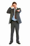 Full length portrait of smiling businessman showing contact me gesture
