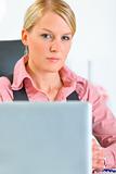 Confident  business woman sitting at office desk. Close-up
