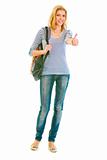 Full length portrait of smiling teen girl with schoolbag showing thumbs up gesture
