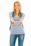 Smiling teen girl with schoolbag giving books
