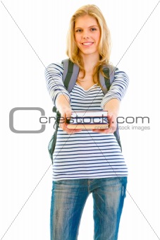 Smiling teen girl with schoolbag giving books
