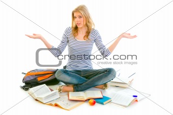 Teengirl with surprise expression on face sitting on floor surrounded by books
