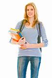 Smiling young girl with schoolbag holding schoolbooks in hands
