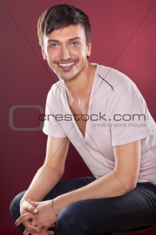 Young handsome man in a white shirt over red