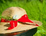 straw hat with red ribbon in the grass