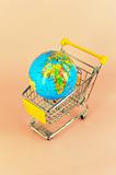 concept of shopping cart with a globe world made of glass 
