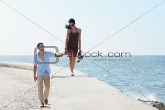 young husband and wife during afternoon walk near the sea