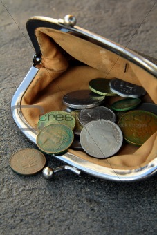 ancient coins in the open vintage purse on a black background