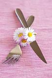 Fork, knife and a small bouquet of white flowers