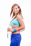 young woman in sports outfit holding a bottle of water smiling - isolated on white