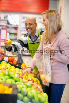 Happy young woman buying fruits