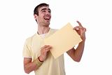 young smiling man holding a yelow sheet of paper in his hand; isolated on the white background. Studio shot.