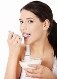 Young beautiful woman eating yogurt
