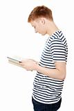 Young teen man is reading a book