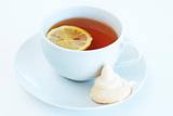 Cup of tea with lemon and meringue cookie
