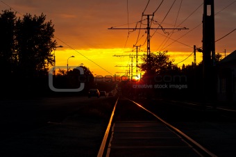 Sunset with traffic and rails in the suburbs