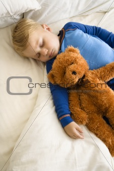 Child sleeping with teddy.