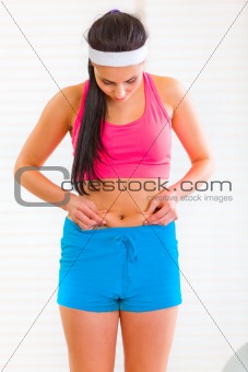 Slim young girl checking her body fat 
