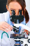 Woman researcher using microscope in medical laboratory. Close up
