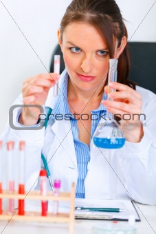Interested woman researcher working with test tubes in laboratory
