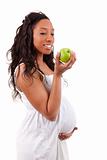 Pregnant african american woman eating an apple