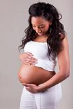 Pregnant african american woman touching her belly