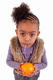 Little black girl drinking orange juice with a straw