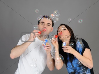 Pretty couple in love blowing bubbles and having fun