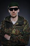 portrait of soldier in camouflage and ammunition . studio shot