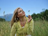 Pretty healthy summer woman outdoors on green field in Alps