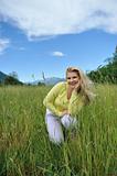 Pretty healthy summer woman outdoors on green field in Alps