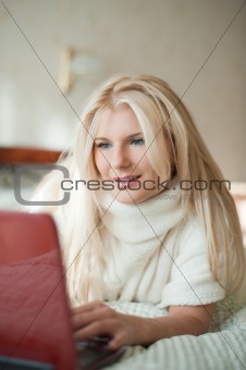 pretty woman surfing in internet with laptop indoors