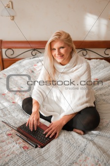 pretty woman surfing in internet with laptop indoors
