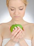 Green apple in a beautiful hand of woman with perfect nail