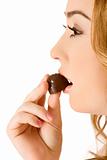 Woman eating chocolate bonbon - (close up)