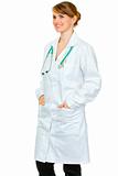 Smiling medical female doctor with hands in pockets of robe looking at copy space
