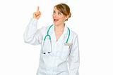 Surprised medical doctor woman with rised finger. Idea gesture
