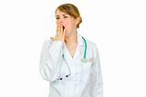 Yawning medical doctor woman holding hand near mouth
