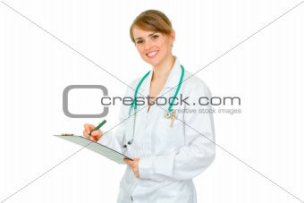 Smiling  doctor woman making notes in medical chart
