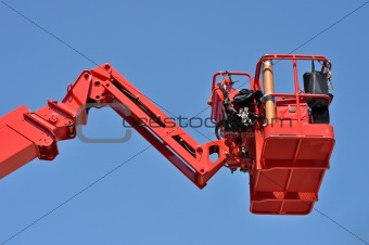 red hydraulic construction cradle against the blue sky