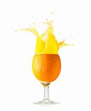orange juice is spalsing in glass