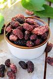 cup of ripe mulberries  on a wooden table