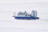 Rescue Service snowmobile patrol on duty in winter on frozen river