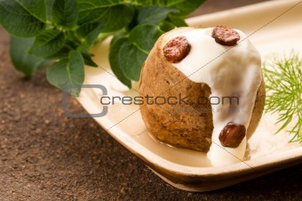 Baked potato with sour cream, greaves and fresh dill