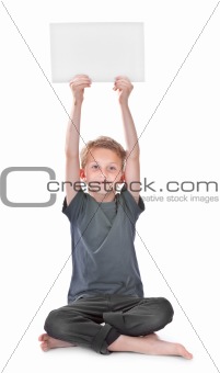 boy sitting and holding a blank white page 