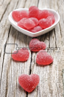 Red heart shaped jelly sweets on wood